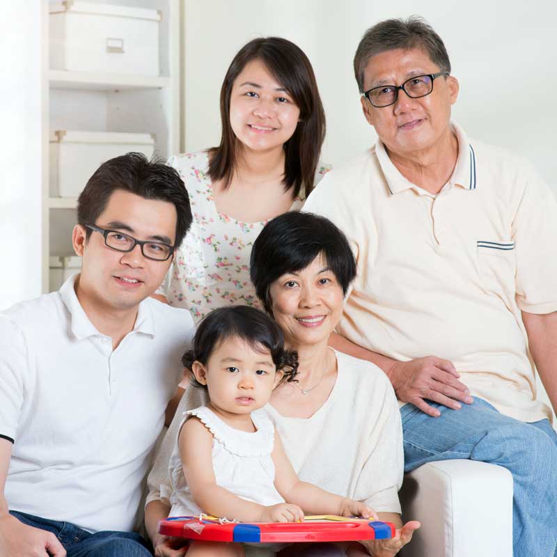 Hawaii Senior Couple and Family – Reverse Mortgage Benefits Senior Hawaiian couple with their family on a lanai overlooking the ocean, showcasing the benefits of Hawaiʻi reverse mortgages for aging in place.